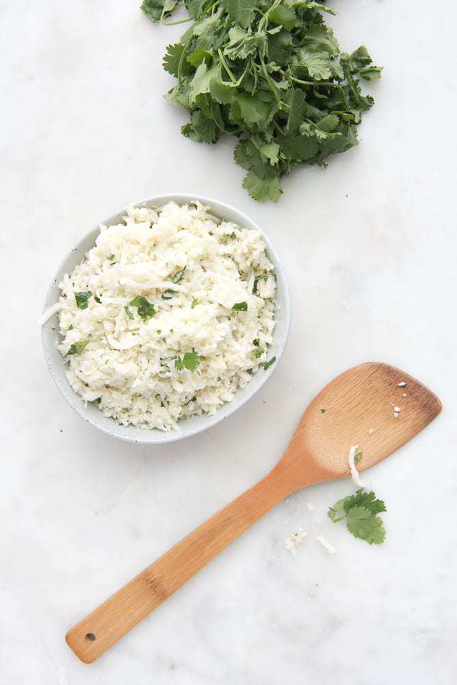 Coconut Cauliflower Rice - a Paleo, gluten-free, Whole30, AIP side dish recipe that takes 10 minutes and is super flavorful. Great with Asian-inspired dishes and for busy nights.