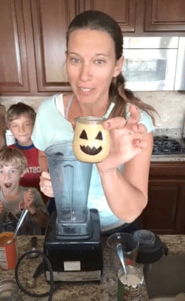 a Facebook Live screenshot showing Michele Spring holding a Pumpkin Milkshake in a jar with a jack-o-lantern face "painted" on with sharpie