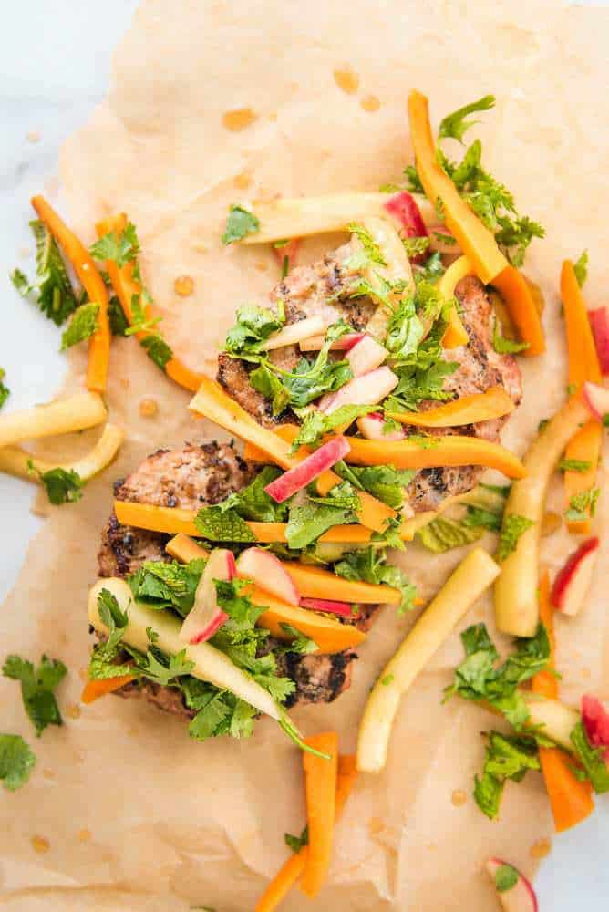 Paleo AIP Banh Mi Burger on parchment paper with the pickled toppings, overhead view