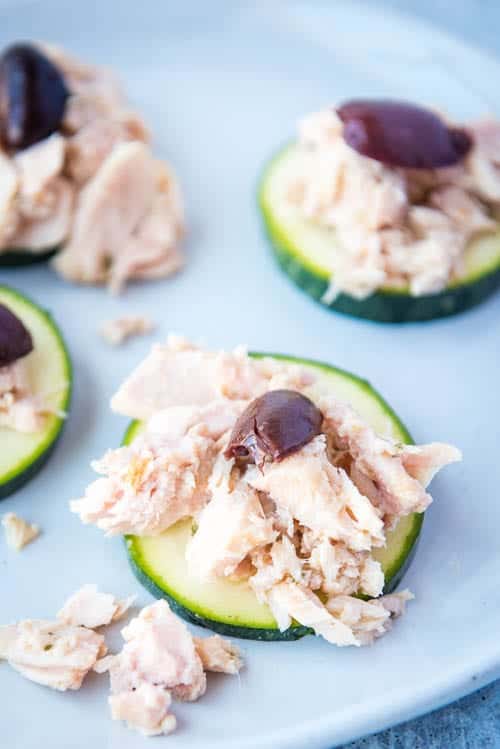 closeup of paleo & aip tuna salad with olives on zucchini rounds as a snack