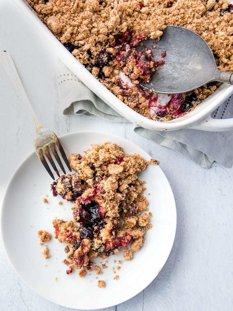 a plate with berry crumble dished out onto it