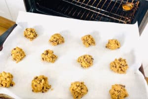 AIP Chocolate Chip Cookies lined up in rows on a baking sheet going into the oven