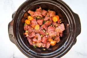 uncooked orange ginger beef in a slow cooker