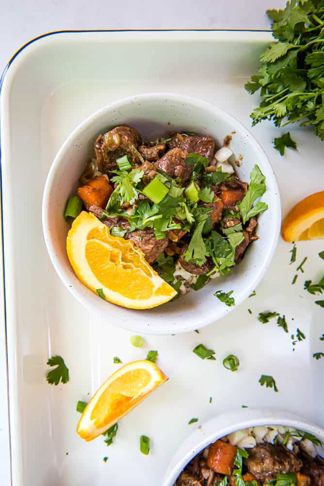 overhead view of orange ginger beef served over cauliflower rice in a bowl