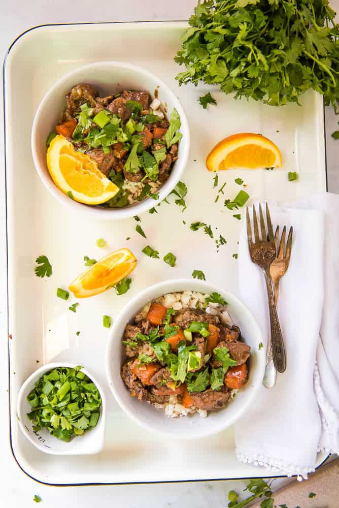 Orange Ginger beef in 2 bowls on a white tray