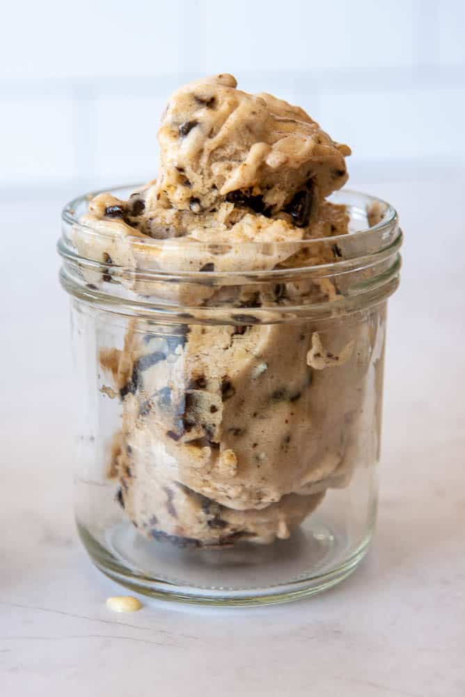 A side view of a single portion sized mason jar containing scoops of AIP Chocolate Chip Ice Cream.