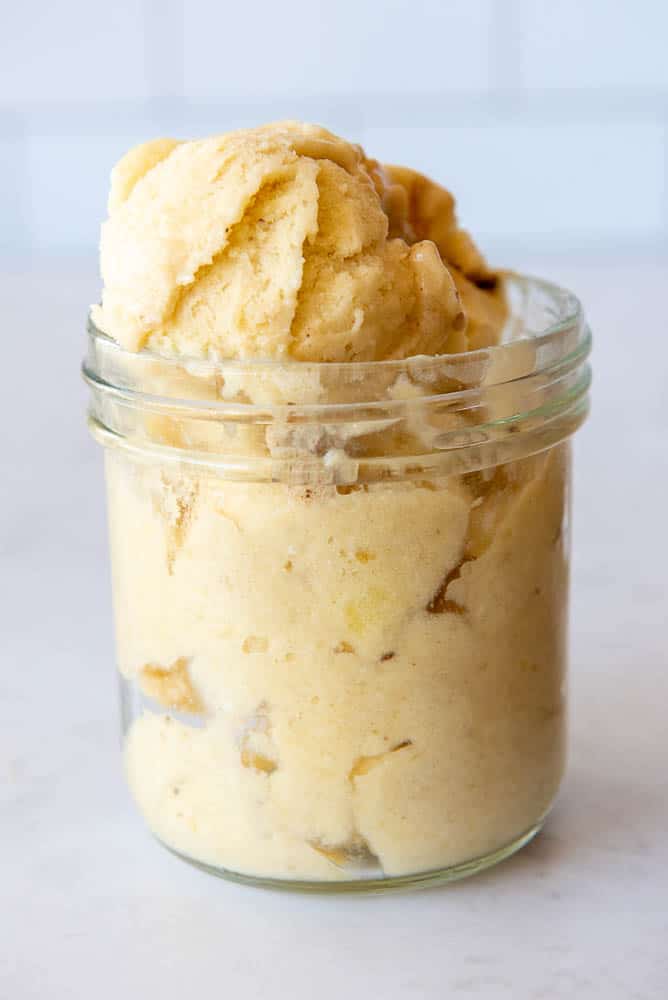A side view of a single-portion sized mason jar containing scoops of AIP Pina Colada Ice Cream.