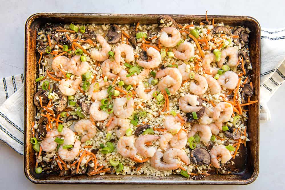 Overhead view of sheet pan with vegetables and shrimp