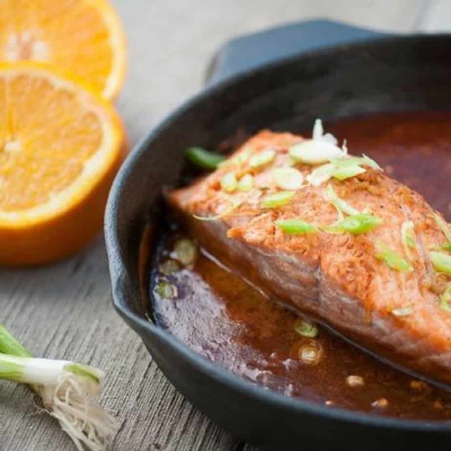 Asian Baked Salmon (Paleo, Whole30, AIP) fish in a pan with orange in the background