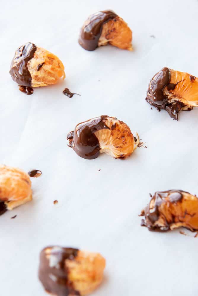 Side view of 7 orange slices dipped in chocolate.